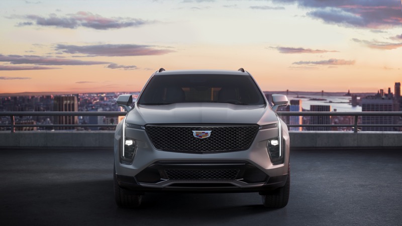 Cadillac XT4 front grille and vertical LED lamps against a city skyline